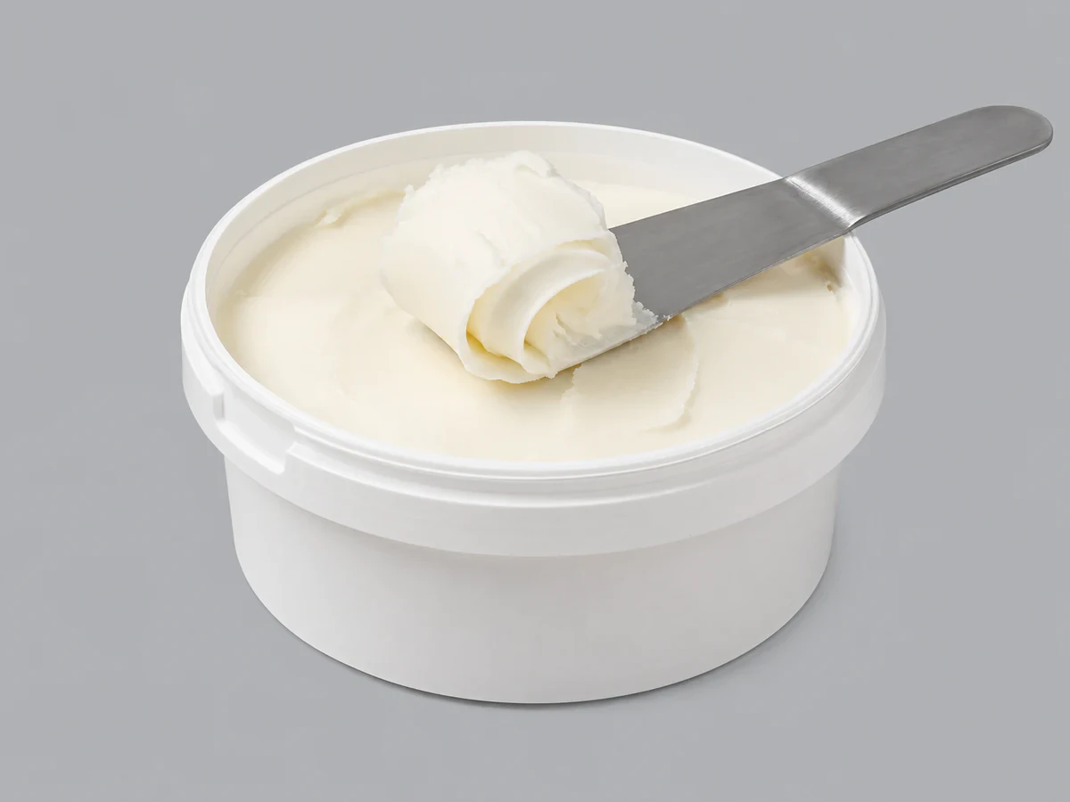 Tub of smooth off-white palm shortening with a plastic, spreadable texture